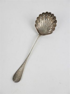 cuillère plaquée argent avec un manche en forme de coquillage sur un fond blanc