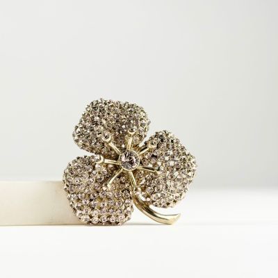 un gros plan d'une bague en or ornée d'un trèfle à quatre feuilles