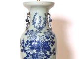 un vase bleu et blanc posé sur une étagère blanche