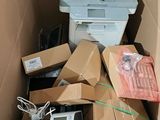 a cardboard box with a printer and other electronic items in it