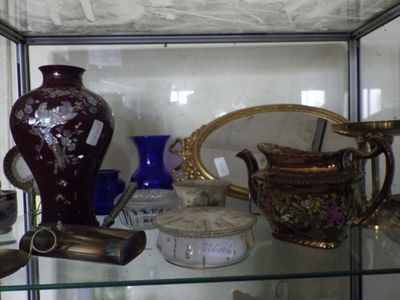 de nombreux vases et autres objets décoratifs exposés dans une vitrine