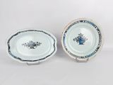 two blue and white plates with flowers on them on a white surface