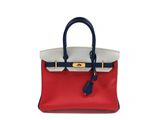 a red and white handbag with a blue handle