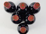 six bottles of wine are arranged in a circle on a white surface