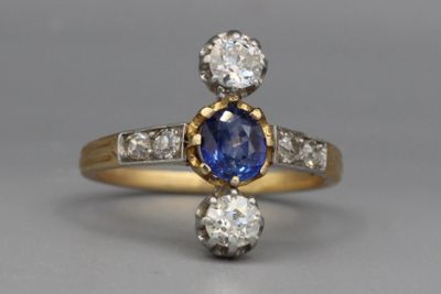 un gros plan d'une bague sertie de diamants et de saphirs posée sur une table