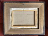an old picture frame sitting on top of a red chair
