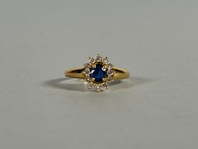 a yellow gold ring with a blue sapphire and white diamonds