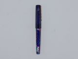 a blue pen sitting on top of a white surface next to a white wall