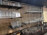il y a beaucoup de verres vides sur les étagères du bar