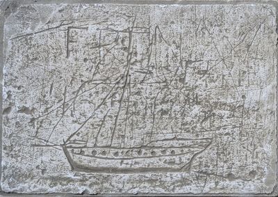 une photo d'une plaque en pierre sur laquelle figure un bateau