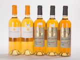 four bottles of wine are lined up on a white surface