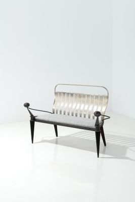 une pièce blanche et vide avec un banc noir et blanc et un mur blanc