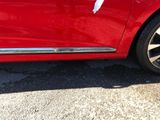 a close up of a red car parked in a parking lot