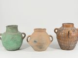 three vases with handles are sitting on a white surface