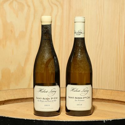 deux bouteilles de vin posées sur un tonneau en bois