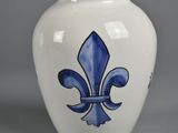 a blue and white vase with a fleur de lis design on it