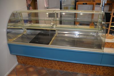 un comptoir bleu avec une vitrine en verre à l'intérieur