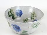 a white bowl with blue and green flowers on it