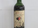 une vieille bouteille de vin posée sur un plan de travail blanc