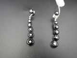 boucles d'oreilles en perles noires et blanches sur un fond noir