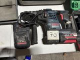 a corded drill and two other tools on a table
