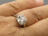 a close up of a person ' s hand holding a diamond ring