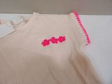 a pink shirt with pink flowers on it sitting on a table