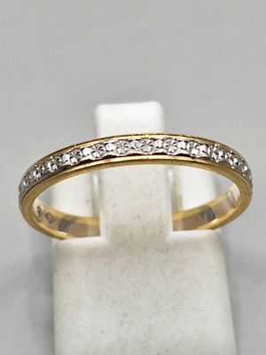 une bague en or et diamants posée sur un socle en marbre blanc