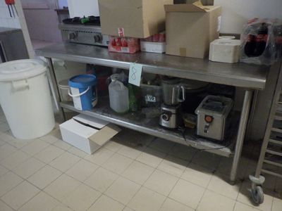 une cuisine où le plan de travail est encombré d'objets