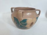 un vase marron orné de motifs bleus et jaunes