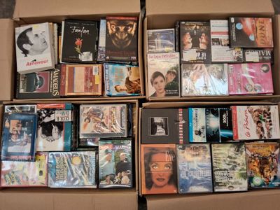un grand nombre de dvd dans une boîte posée sur le sol