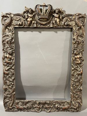 an ornate silver frame with a crown on top of it