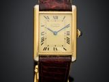 a close up of a gold wrist watch with roman numerals