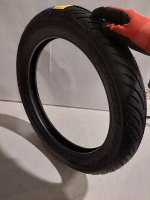 someone is holding a tire with a rubber glove on top of it