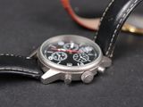 a close up of a watch on a black surface