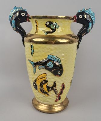 un vase jaune orné de poissons peints