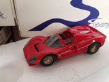 a red toy car sitting on a white surface