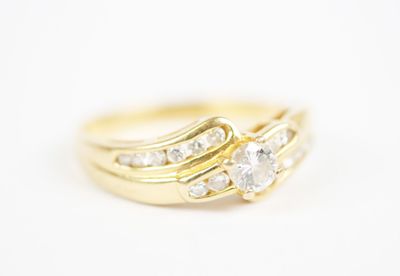 a close up of a yellow gold ring with three diamonds
