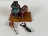 a figurine of a woman with a suitcase and a pair of scissors