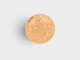 a gold coin sitting on top of a white surface