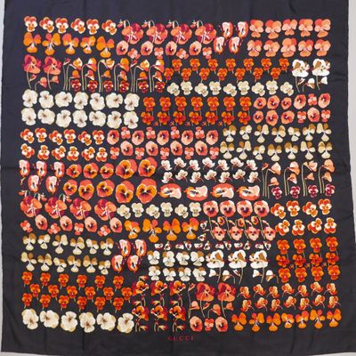 an image of a black and orange floral print scarf hanging on a wall