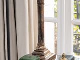 une lampe posée sur une table devant une fenêtre