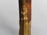 a close up of the legs of a wooden table with a clock on top of it