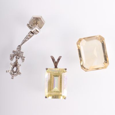 une photo représentant une paire de boucles d'oreilles et un pendentif posés sur une surface blanche