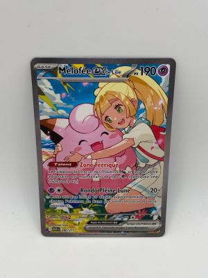 un gros plan sur une carte Pokémon représentant une fillette qui serre un cochon dans ses bras
