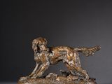 a bronze statue of a dog on a wooden base