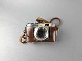 an old camera with a leather strap sitting on top of a table