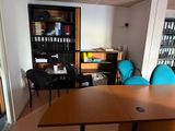a table and chairs in a room with bookshelves