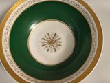 une assiette verte et dorée ornée d'un flocon de neige