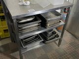 une table en métal sur laquelle sont posées tout un tas d'assiettes et de casseroles